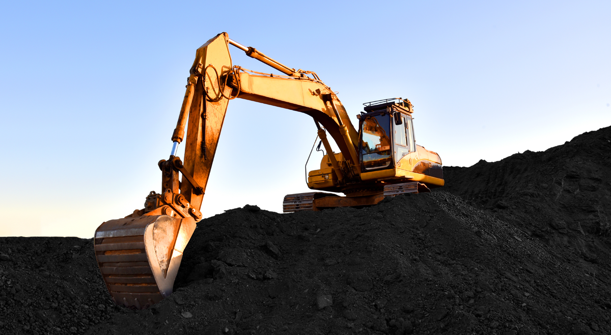 Mining digger on pile of soil